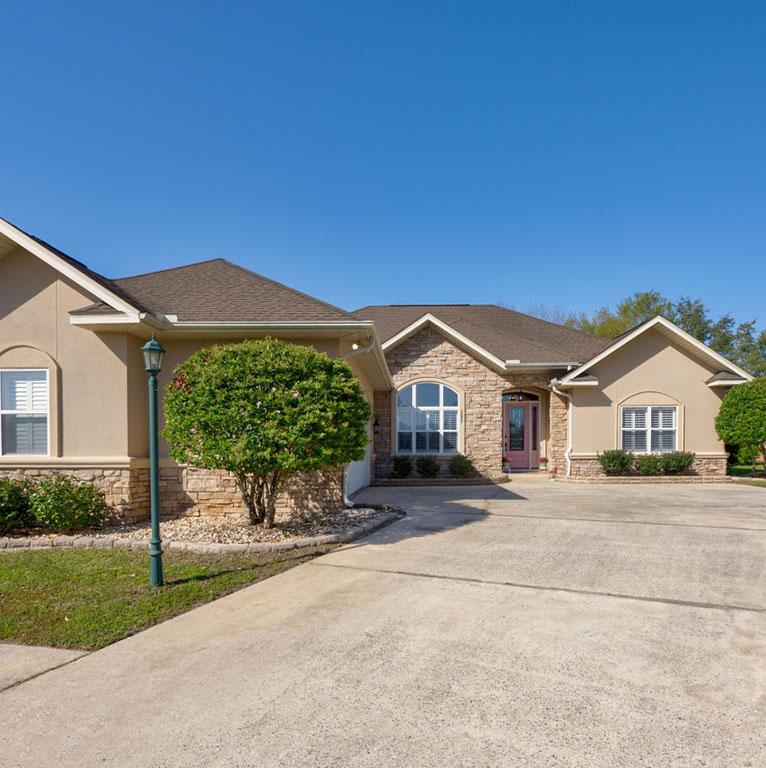 Stone-accented Northwest Florida home under a clear blue sky